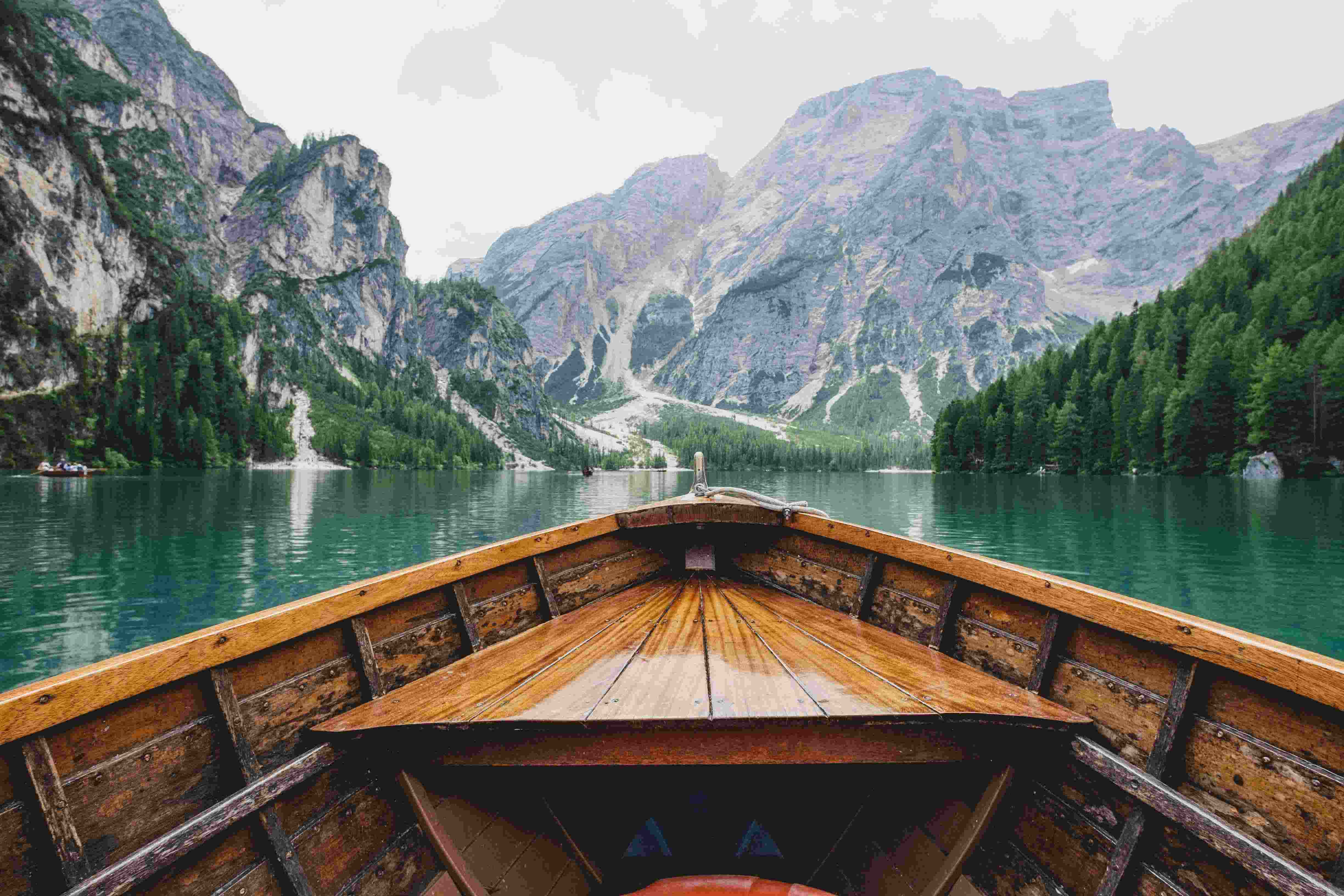 picture, wooden boat on a lake surrounded by mountains