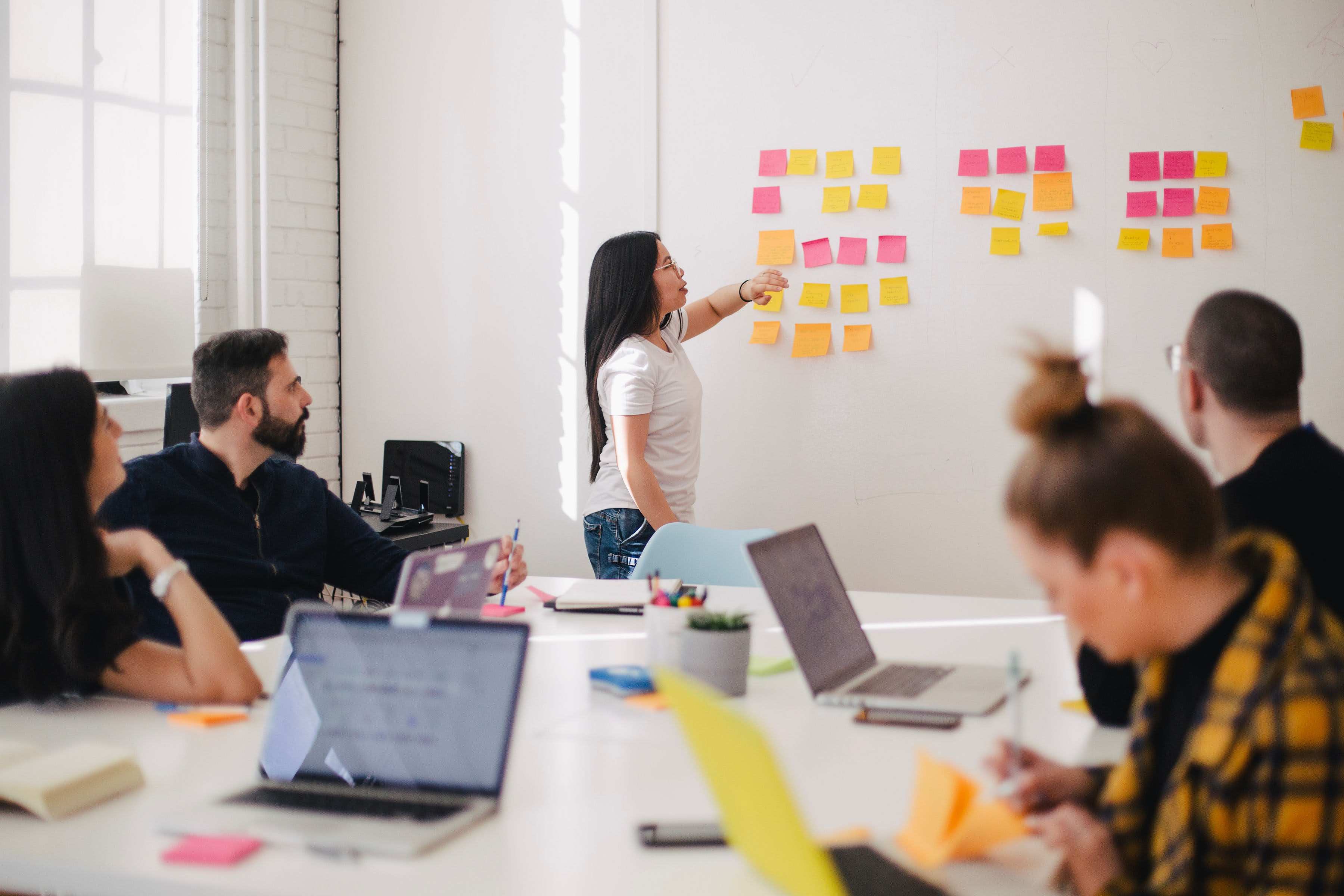 picture, woman doing a presentation in front of a post-it covered wall