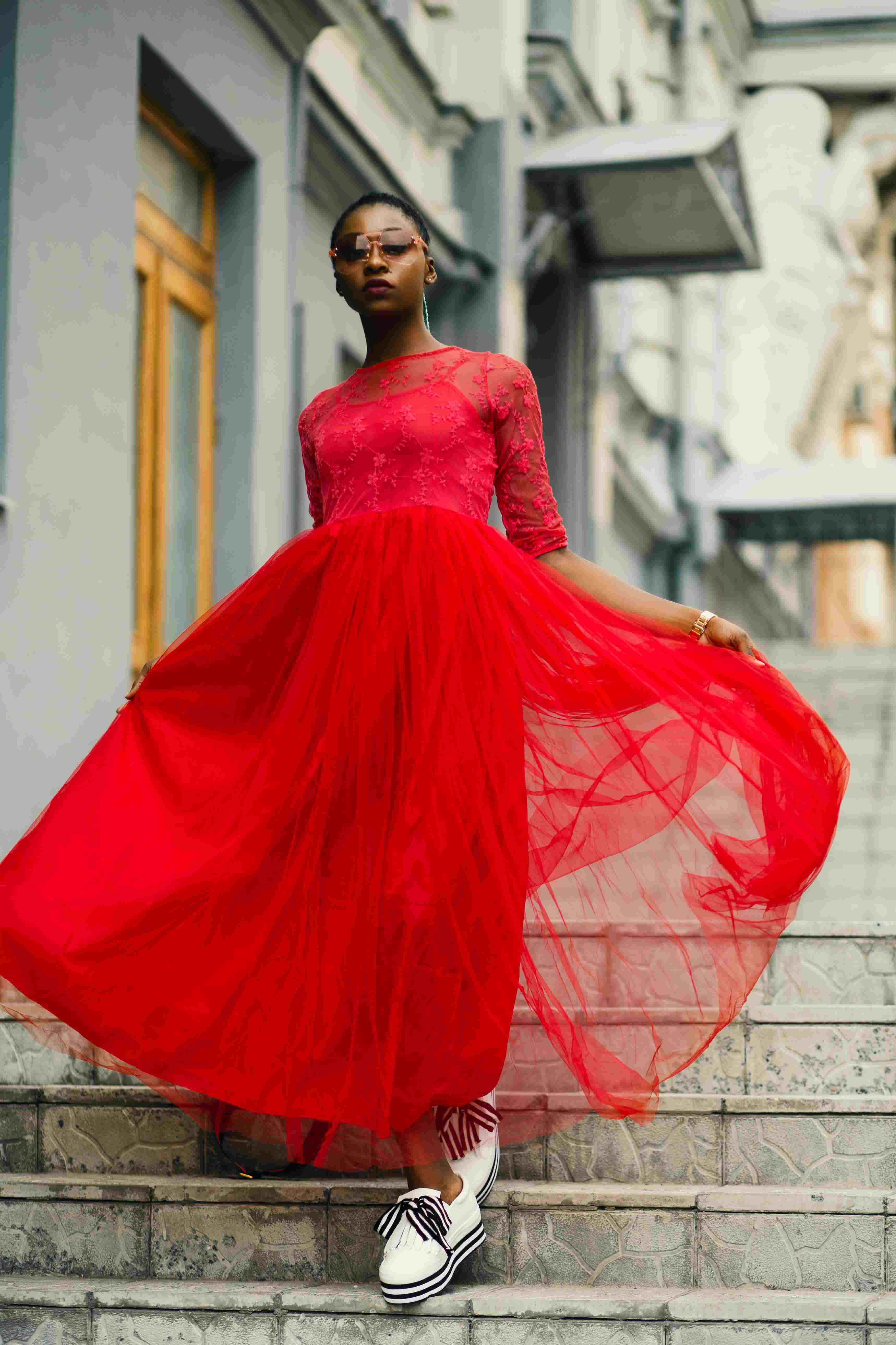 picture, woman wearing a red tulle dress going down stairs